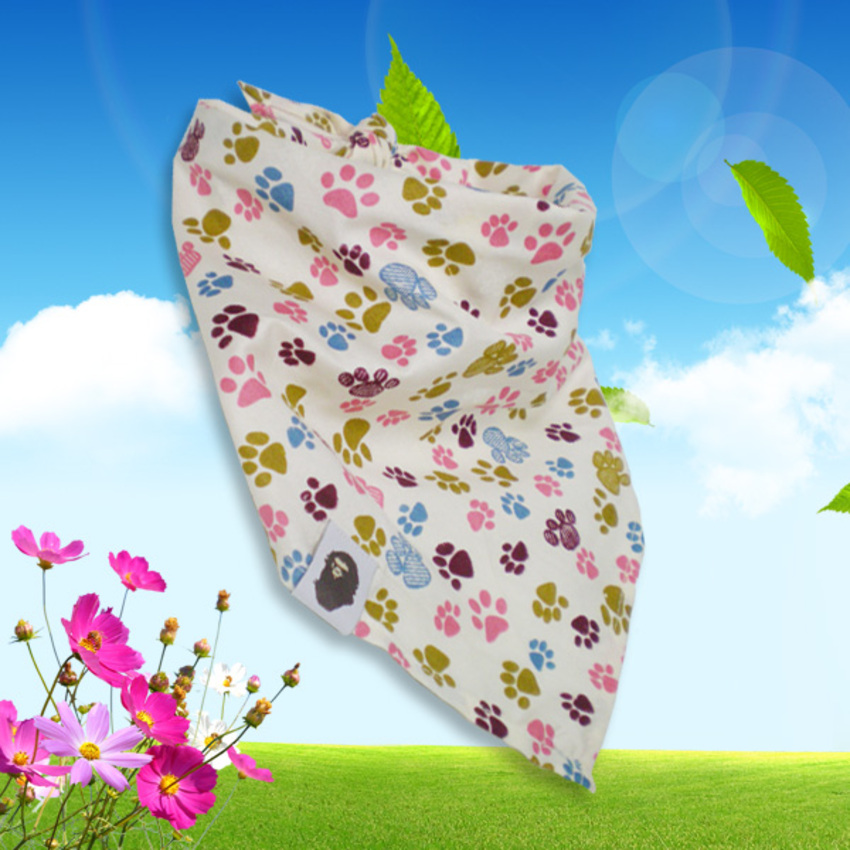 Vrolijke hondensjaal met een motief van gekleurde pootafdrukken op een witte achtergrond in de kleuren babyblauw, roze, olijfgroen en paars. Deze bandana is gemaakt van 100% katoen en kan goed op 30 graden gewassen worden.